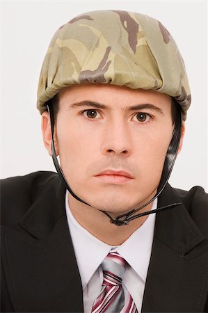 simsearch:625-02931241,k - Portrait of a businessman wearing an army helmet Fotografie stock - Premium Royalty-Free, Codice: 625-02931257