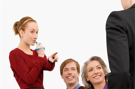 fischietto - Businesswoman blowing whistle with three business executives beside her Fotografie stock - Premium Royalty-Free, Codice: 625-02931340