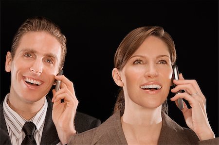 Business executives talking on mobile phones and smiling Stock Photo - Premium Royalty-Free, Code: 625-02931357