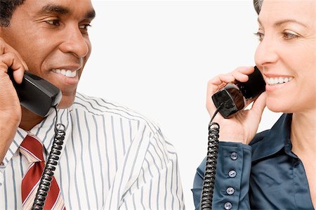 simsearch:625-02932799,k - Businessman and a businesswoman talking on landline phones Foto de stock - Sin royalties Premium, Código: 625-02931358