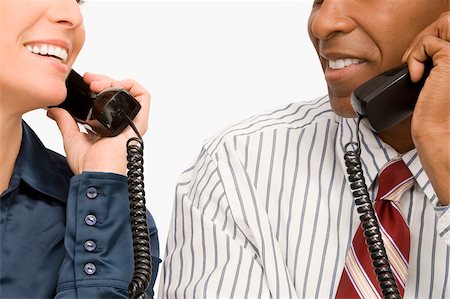 simsearch:625-02932799,k - Businessman and a businesswoman talking on landline phones Foto de stock - Sin royalties Premium, Código: 625-02931405