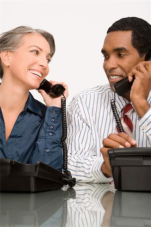 simsearch:625-02933216,k - Businessman and a businesswoman talking on landline phones Foto de stock - Sin royalties Premium, Código: 625-02931408