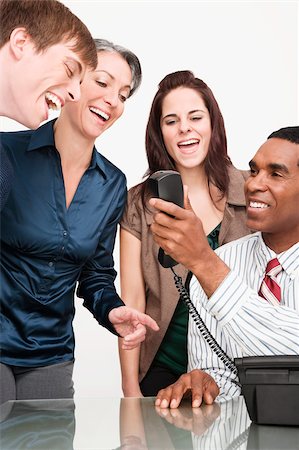 simsearch:625-02931305,k - Homme d'affaires en tenant un téléphone avec trois hommes d'affaires souriant Photographie de stock - Premium Libres de Droits, Code: 625-02931411