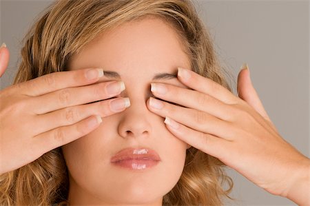 Close-up of a young woman covering her eyes with her hands Fotografie stock - Premium Royalty-Free, Codice: 625-02931453