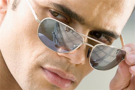 peeping fashion - Gros plan d'un homme adult moyen regardant au-dessus de ses lunettes de soleil Photographie de stock - Premium Libres de Droits, Code: 625-02931492