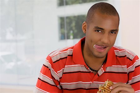 Portrait of a young man eating a sandwich Stock Photo - Premium Royalty-Free, Code: 625-02931510
