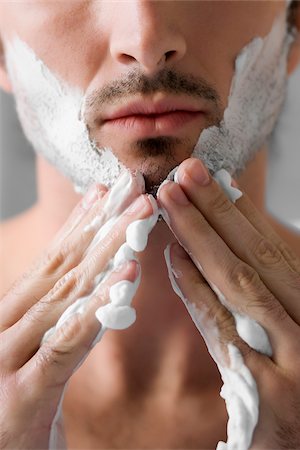 shaving (hygiene) - Gros plan d'un jeune homme, appliquer la crème à raser sur le visage Photographie de stock - Premium Libres de Droits, Code: 625-02931526