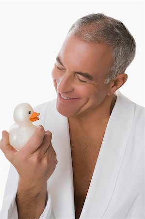 Close-up of a senior man holding a toy duck and smiling Stock Photo - Premium Royalty-Free, Code: 625-02931538