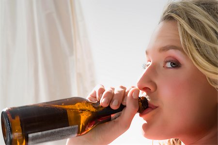 Portrait of a young woman drinking beer Fotografie stock - Premium Royalty-Free, Codice: 625-02931605