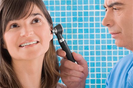 doctor with adult patient and happy not child not hospital not bed - Close-up of a male doctor examining a mature woman's ear Stock Photo - Premium Royalty-Free, Code: 625-02931634