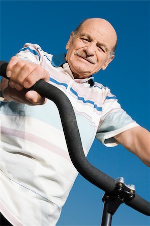 Low angle view of a senior man on a bicycle Stock Photo - Premium Royalty-Free, Code: 625-02931667