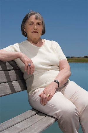 Portrait of a senior woman sitting on a bench at the lakeside Stock Photo - Premium Royalty-Free, Code: 625-02931750