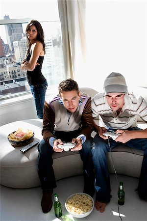 simsearch:625-02931506,k - Two young men playing video game with a young woman standing behind them Stock Photo - Premium Royalty-Free, Code: 625-02931801