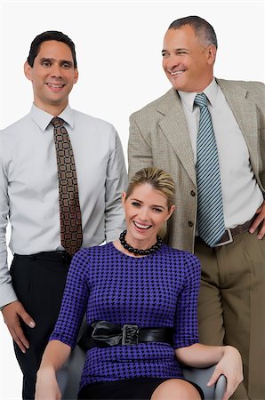 simsearch:625-00850993,k - Close-up of a businesswoman smiling with two businessmen standing behind her Stock Photo - Premium Royalty-Free, Code: 625-02931841