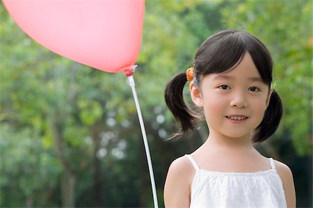 Portrait of a girl with a balloon and smiling Stock Photo - Premium Royalty-Free, Code: 625-02931858
