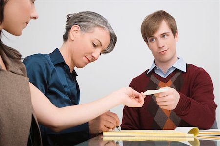 Businessman giving a paper to a businesswoman Stock Photo - Premium Royalty-Free, Code: 625-02931897