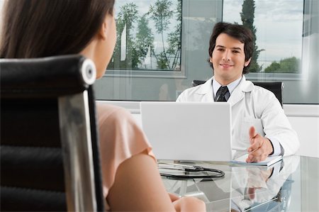 Male doctor talking to a woman in a clinic Stock Photo - Premium Royalty-Free, Code: 625-02931963