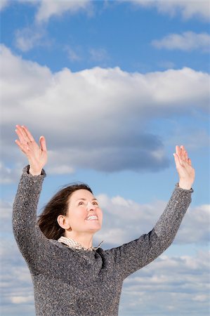 simsearch:6102-04929804,k - Mature woman standing with her arms raised and looking up Stock Photo - Premium Royalty-Free, Code: 625-02932049