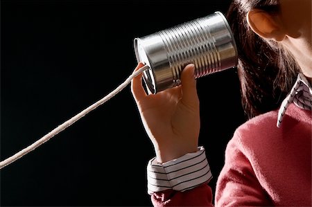 Close-up of a businesswoman using tin can phone Stock Photo - Premium Royalty-Free, Code: 625-02932057