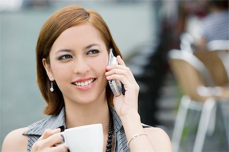 simsearch:625-00803005,k - Gros plan d'une jeune femme tenant une tasse de café et de parler sur un téléphone mobile Photographie de stock - Premium Libres de Droits, Code: 625-02932053