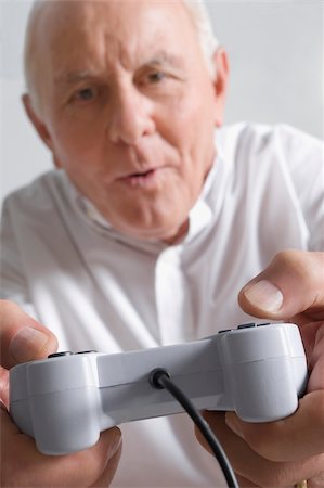 Portrait d'un homme supérieur, jouer à un jeu vidéo Photographie de stock - Premium Libres de Droits, Code: 625-02932078