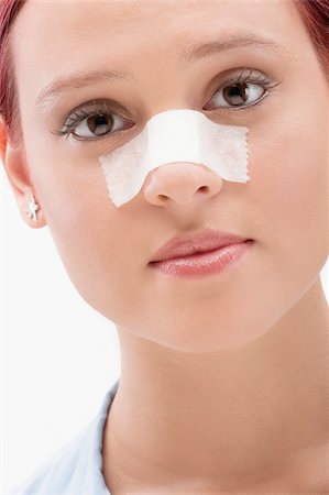 Close-up of a female patient with an adhesive bandage on her nose Fotografie stock - Premium Royalty-Free, Codice: 625-02932108