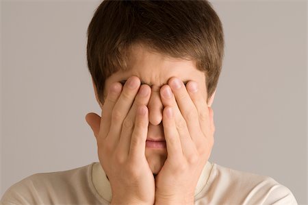 Close-up of a young man covering his eyes with his hands Fotografie stock - Premium Royalty-Free, Codice: 625-02932161