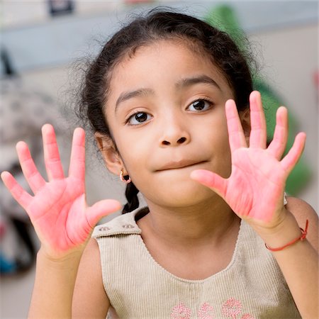 Portrait of a girl showing paint covered hands Stock Photo - Premium Royalty-Free, Code: 625-02932204