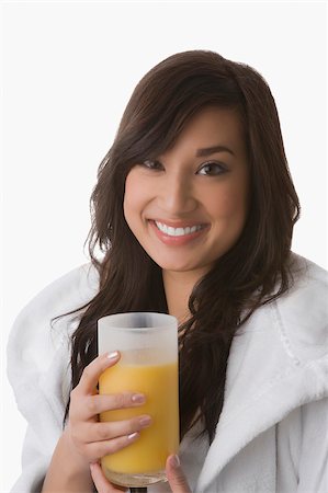 simsearch:625-00898861,k - Portrait d'une jeune femme tenant un verre de jus d'orange et souriant Photographie de stock - Premium Libres de Droits, Code: 625-02932332