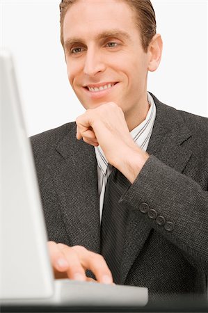 simsearch:630-03481503,k - Close-up of a businessman working on a laptop and smiling Fotografie stock - Premium Royalty-Free, Codice: 625-02932403