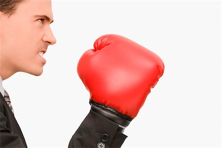 disdain - Side profile of a businessman wearing boxing gloves Stock Photo - Premium Royalty-Free, Code: 625-02932413