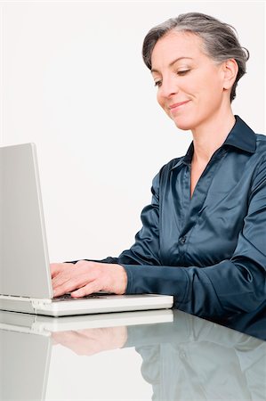 simsearch:625-02267018,k - Femme d'affaires travaillant sur un ordinateur portable et souriant Photographie de stock - Premium Libres de Droits, Code: 625-02932445