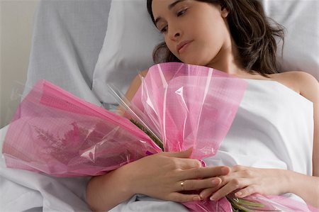 plastic flowers - Female patient lying on the bed and holding a bouquet of flowers Stock Photo - Premium Royalty-Free, Code: 625-02932454