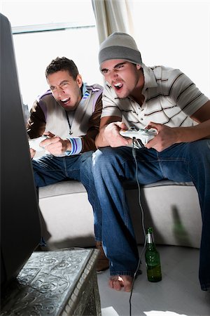 Young men playing a video game Foto de stock - Sin royalties Premium, Código: 625-02932465