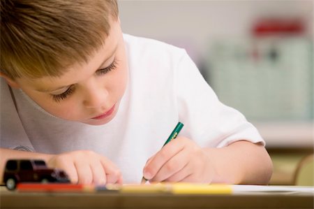 Close-up of a boy drawing on a sheet of paper Foto de stock - Sin royalties Premium, Código: 625-02932488