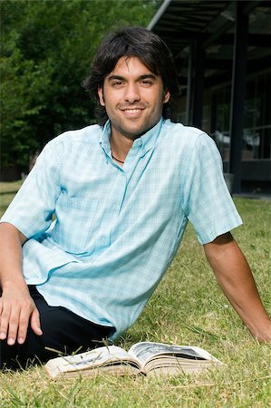 Portrait d'un jeune homme assis dans une pelouse et souriant Photographie de stock - Premium Libres de Droits, Code: 625-02932497