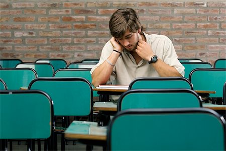 desk with wall - Young man sitting in a classroom Stock Photo - Premium Royalty-Free, Code: 625-02932490