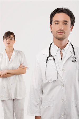 simsearch:625-02929220,k - Portrait of a male doctor with a female doctor standing in the background Stock Photo - Premium Royalty-Free, Code: 625-02932520
