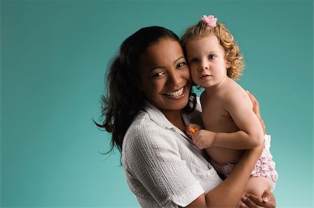 simsearch:625-02267467,k - Portrait of a young woman carrying her daughter and smiling Stock Photo - Premium Royalty-Free, Code: 625-02932551
