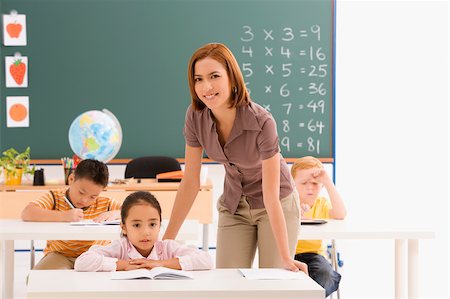 Female teacher teaching her students in a classroom Foto de stock - Sin royalties Premium, Código: 625-02932576