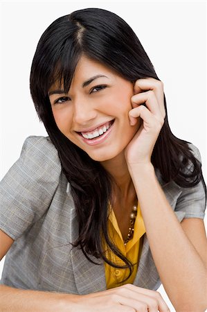 Portrait of a young woman smiling with her hand on her chin Stock Photo - Premium Royalty-Free, Code: 625-02932614