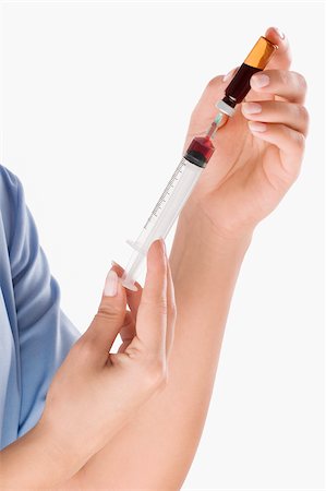 Close-up of a person's hand filling an injection from a vial Stock Photo - Premium Royalty-Free, Code: 625-02932745