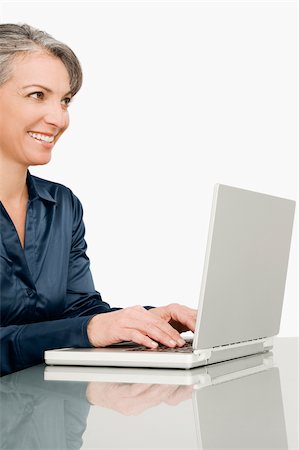 simsearch:625-02267018,k - Femme d'affaires travaillant sur un ordinateur portable et souriant Photographie de stock - Premium Libres de Droits, Code: 625-02932759
