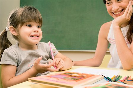 Female teacher smiling with her student sitting beside her Foto de stock - Sin royalties Premium, Código: 625-02932838