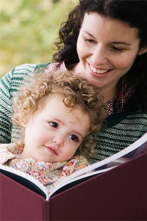 simsearch:625-02266718,k - Close-up of a mid adult woman looking at a picture book with her daughter Fotografie stock - Premium Royalty-Free, Codice: 625-02932959