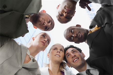 Low angle view of a group of business executives in huddle Foto de stock - Royalty Free Premium, Número: 625-02932952