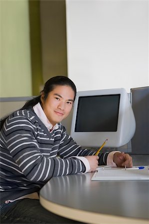 simsearch:625-02930319,k - Portrait of a young man sitting in a classroom and writing Stock Photo - Premium Royalty-Free, Code: 625-02932965