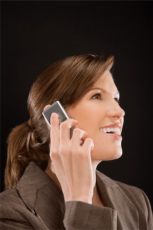 Close-up of a businesswoman talking on a mobile phone and smiling Foto de stock - Sin royalties Premium, Código: 625-02932970