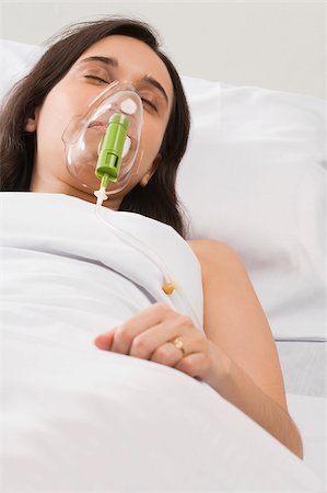 High angle view of a female patient wearing an oxygen mask Foto de stock - Sin royalties Premium, Código: 625-02933023