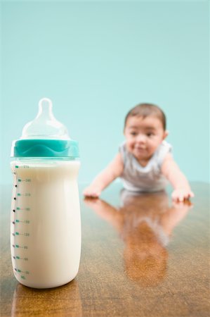 Close-up of a milk bottle with a baby boy in the background Foto de stock - Sin royalties Premium, Código: 625-02933052